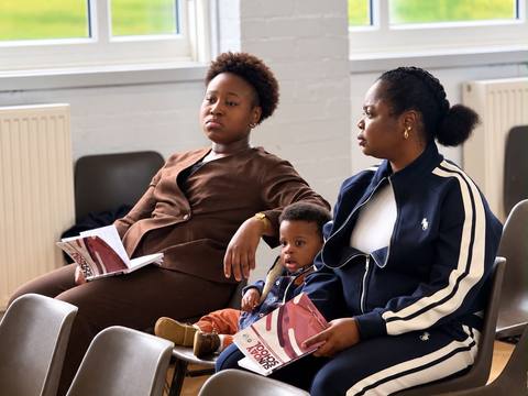 Mothers seated during a church event with a child